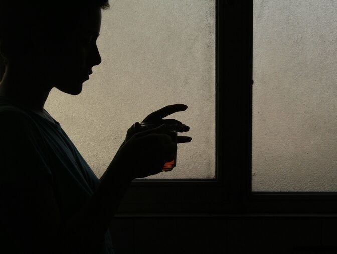 silhouette holding a glass silhouette holding a glass