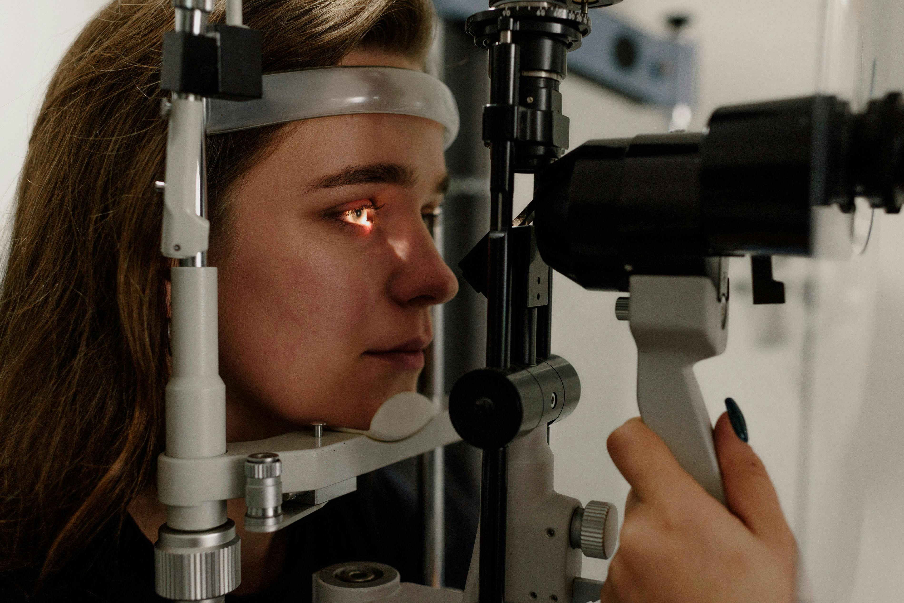 an eye doctor looking at a young woman's eyes