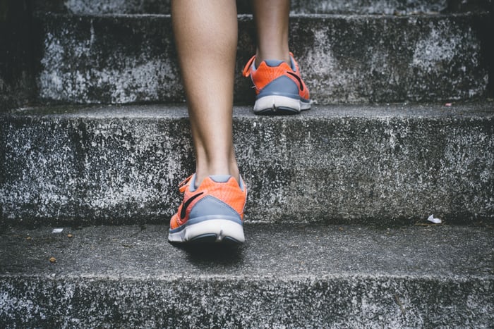 back of woman's feet climbing concrete steps